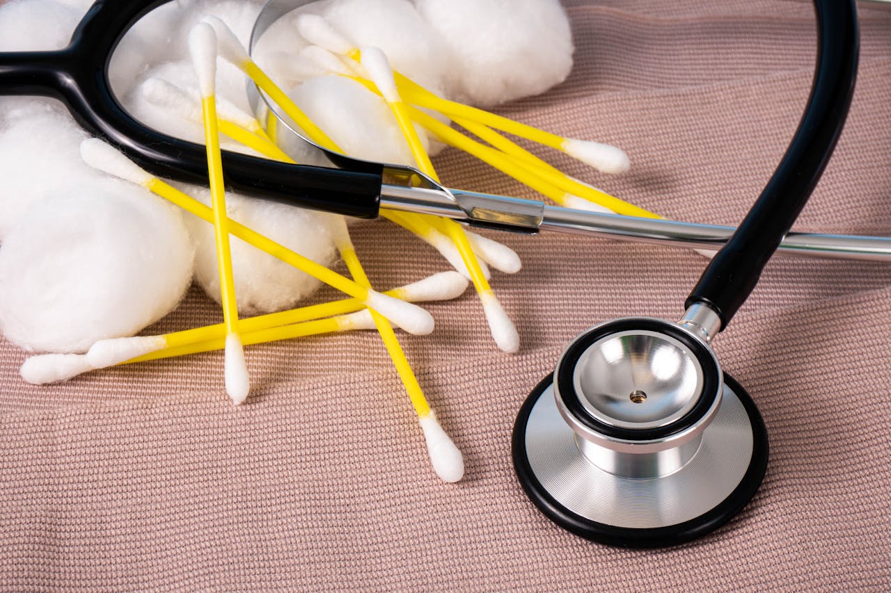Detailed image of cotton swabs and a stethoscope on a textile surface, ideal for healthcare themes.